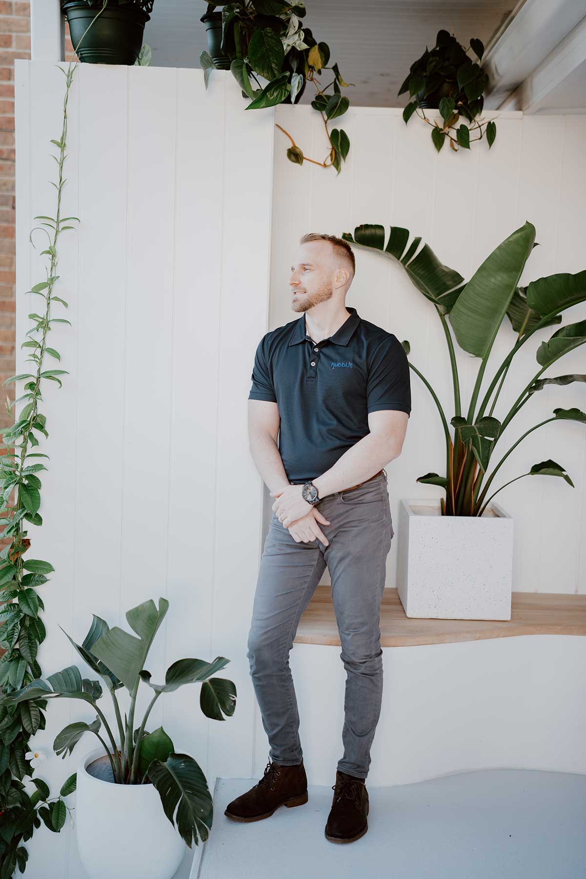 Picture of Central Coast mortgage broker Matthew Gleeson of Hubblit - wearing Hubblit branded navy polo, white background and greenry facing away from camera