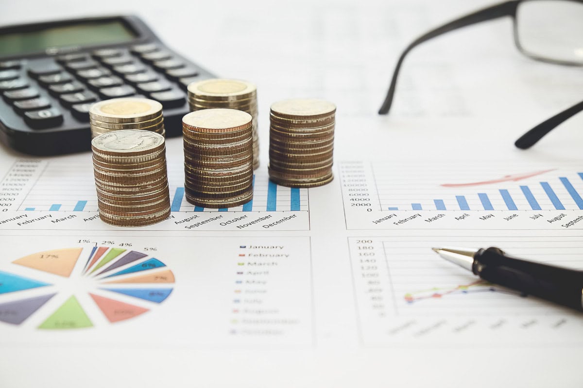 financial data sheets and coins stacked to depict a meeting showing what is an offset account and how does it work