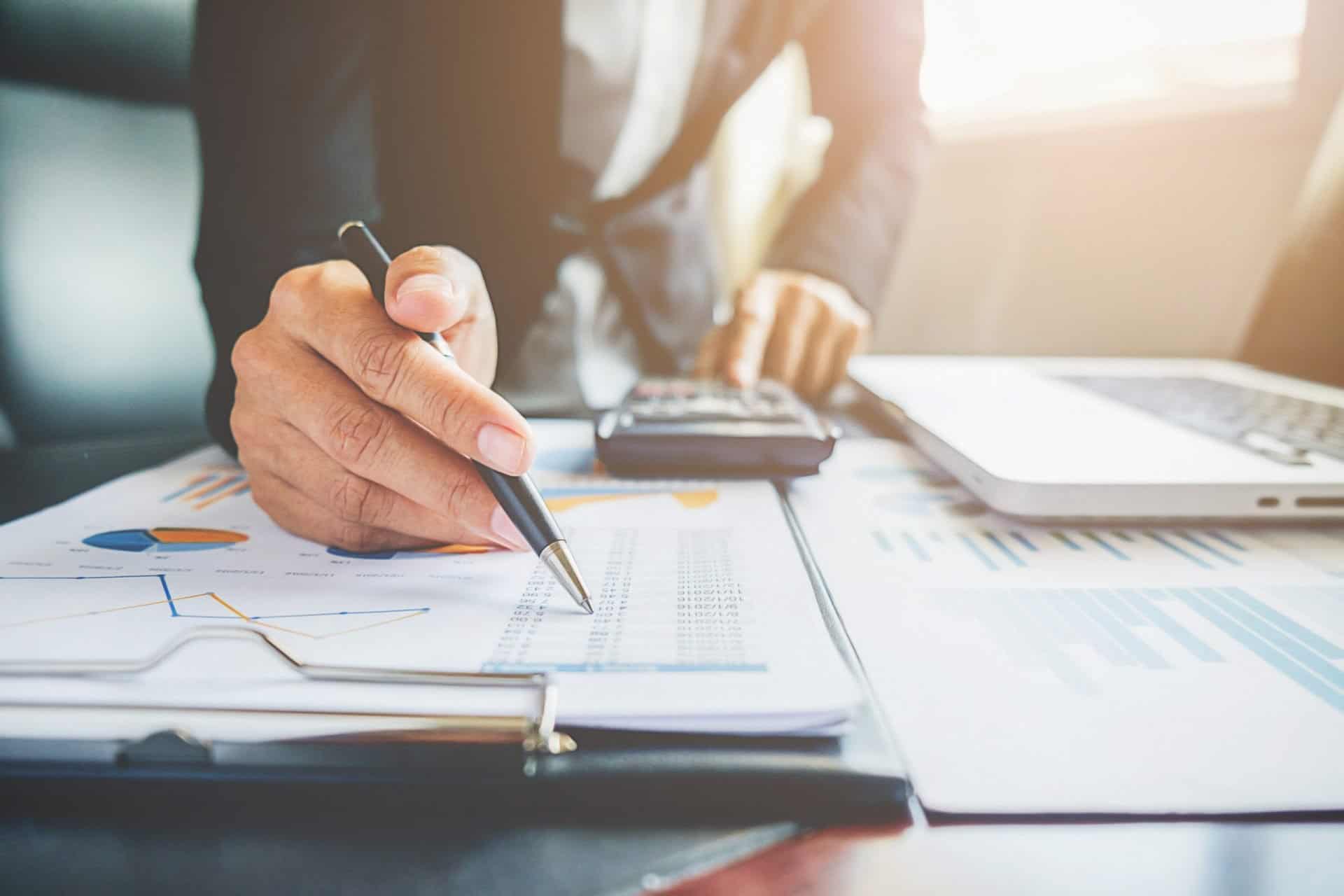 businessman working on business paperwork - close up of paper and hand with pen in it