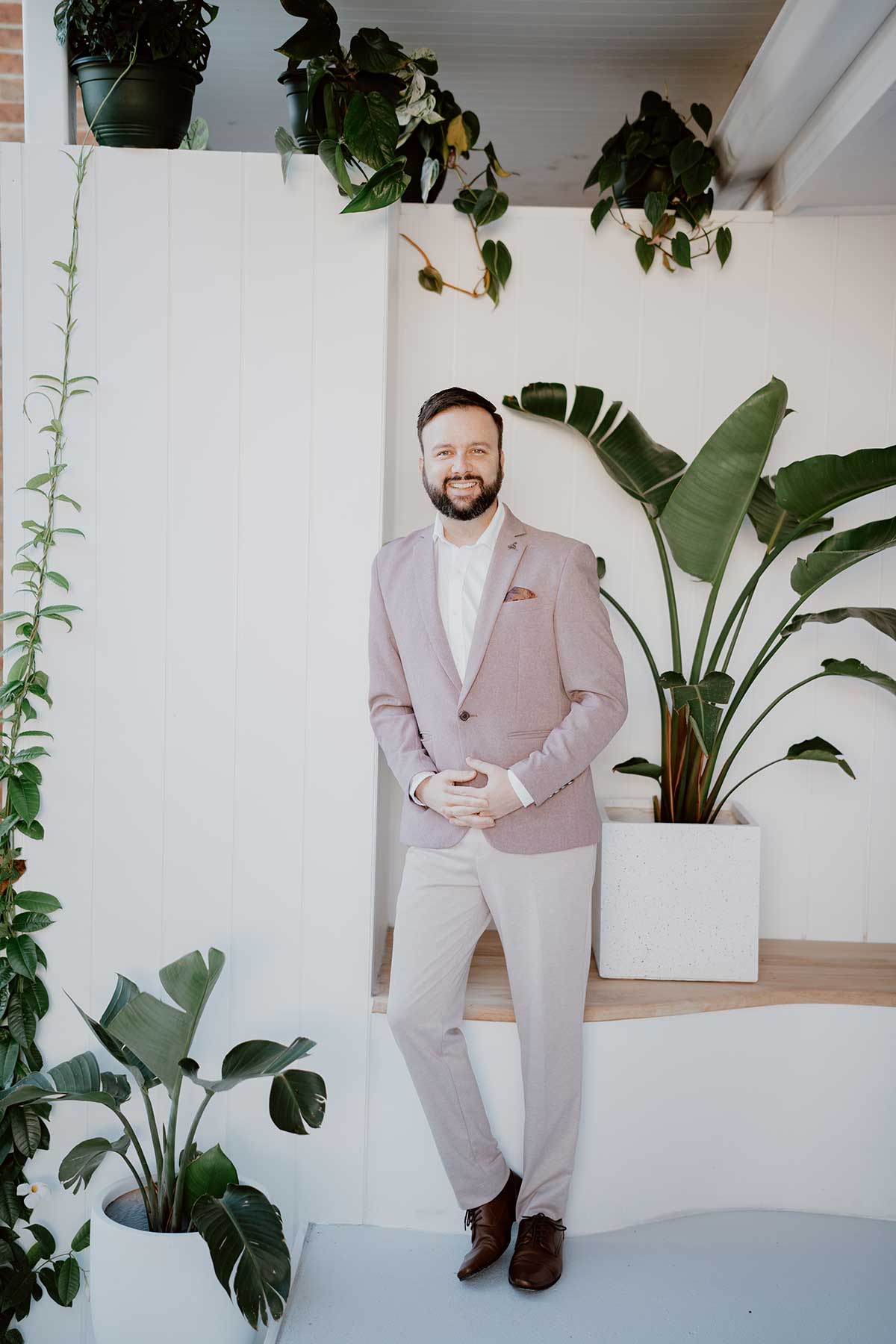 Picture of Central Coast mortgage broker Jarred Spur of Hubblit - neutral suit, white background and greenry facing camera